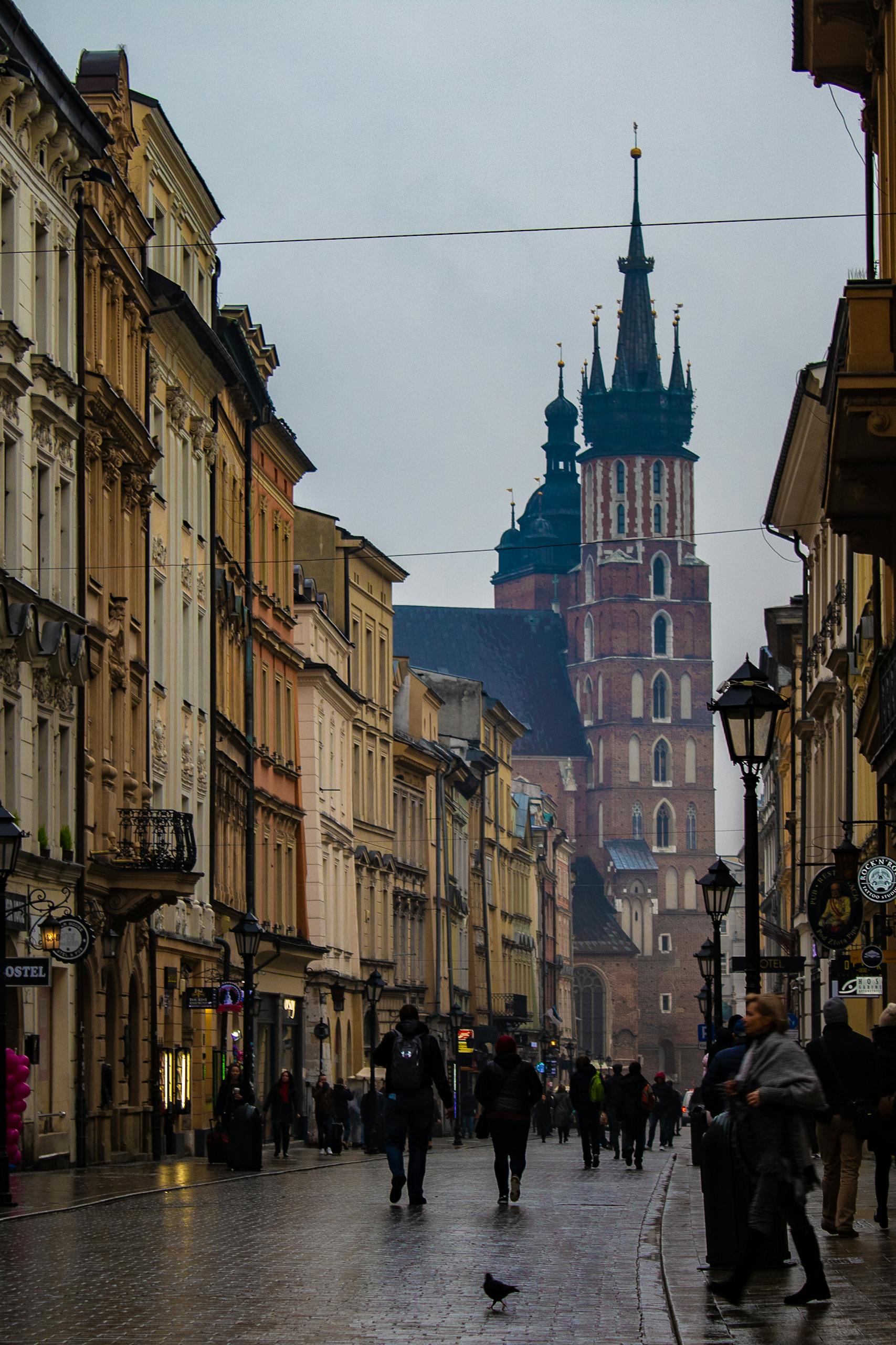 A bustling street scene in Krakow's Old Town, featuring St. Mary's Basilica.