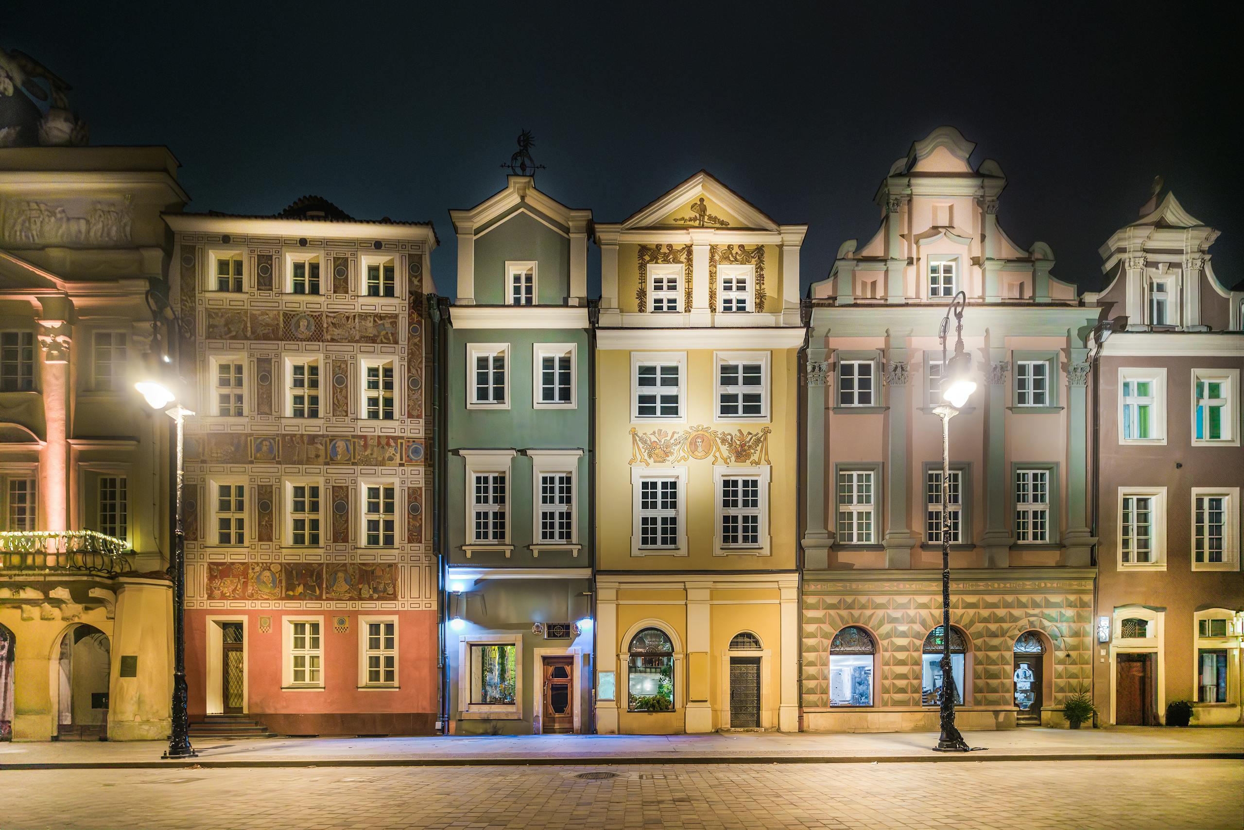 Stunning night view of colorful historic buildings in Poznań, Poland's Old Town Square.