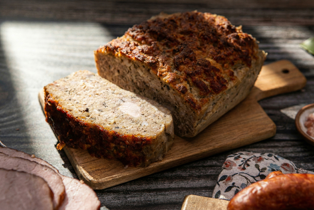 Fotografia garmażeryjna: plastry pasztetu z pietruszką – zbliżenie na strukturę wyrobu.