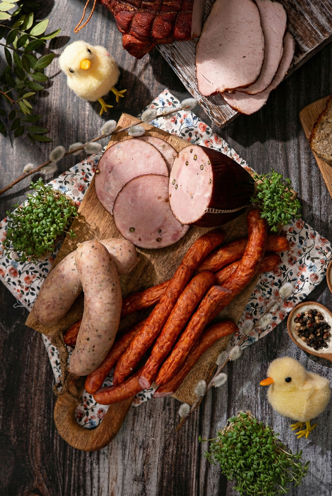 Wielkanocna sesja zdjęciowa: deska wędlin z kiełbasą białą i kabanosami.